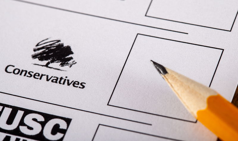 close up of voting card pen hovering over conservative box